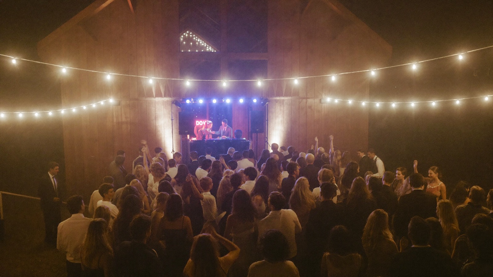 Wedding reception dance floor glowing under warm string lights