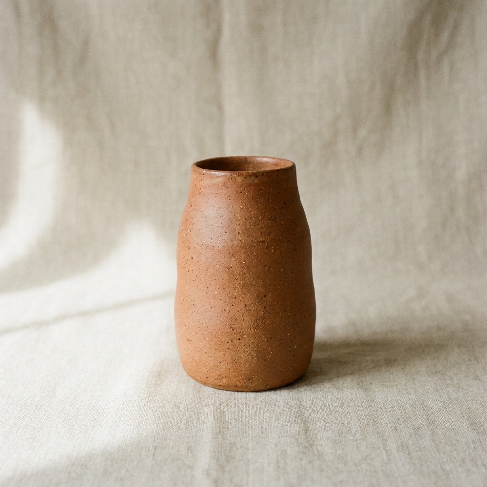 Wheel-thrown terracotta vase on oatmeal linen