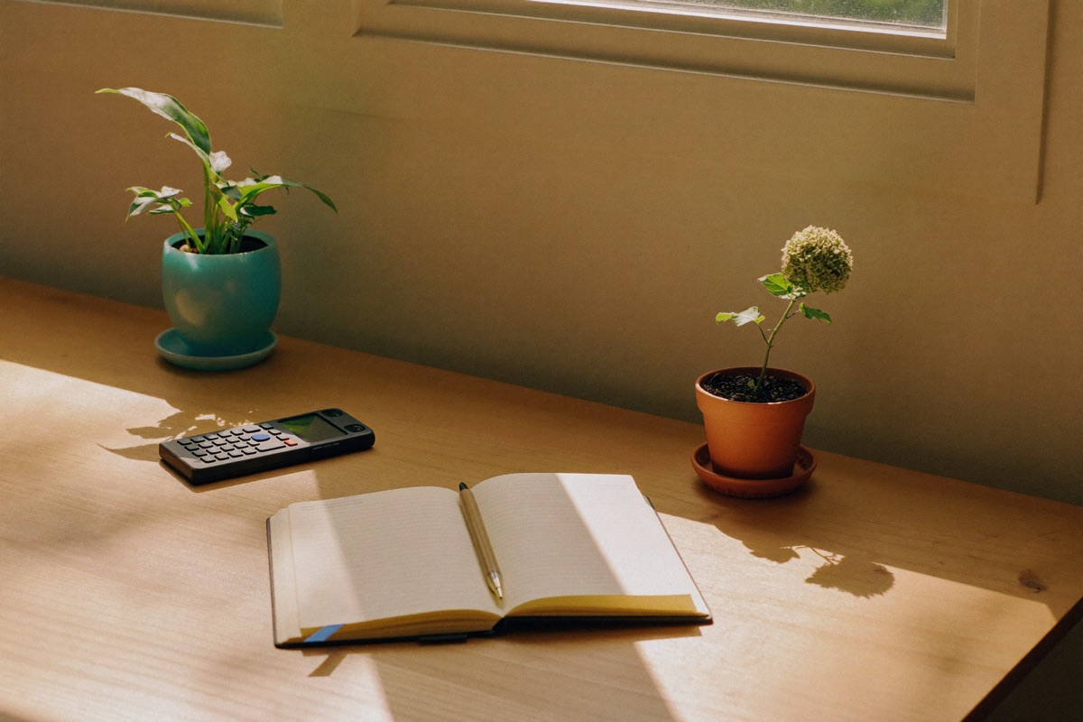 A warm desk with a phone, notebook, and coffee — ready for a conversation